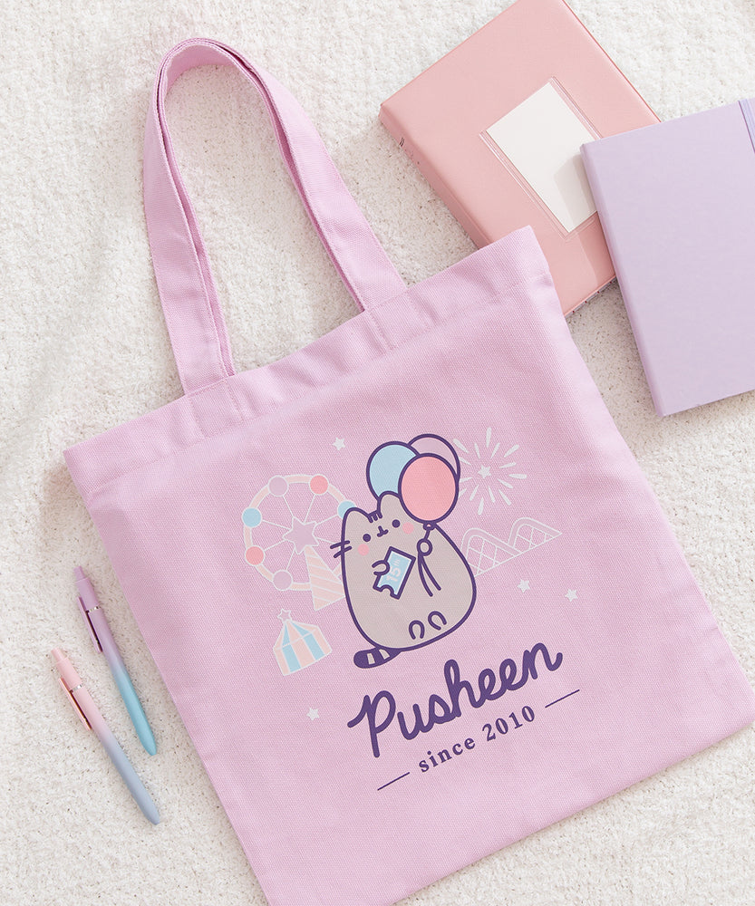 A purple canvas bag with pink, blue, purple, white, and grey, printed graphic ties on a flat background.