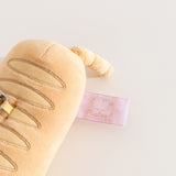 Close-up of the pink cggcw tag on the side of the Pusheen Baguette Reusable Bag Keychain Plush. 