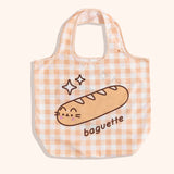 Yellow gingham nylon tote bag lies on a yellow surface. 