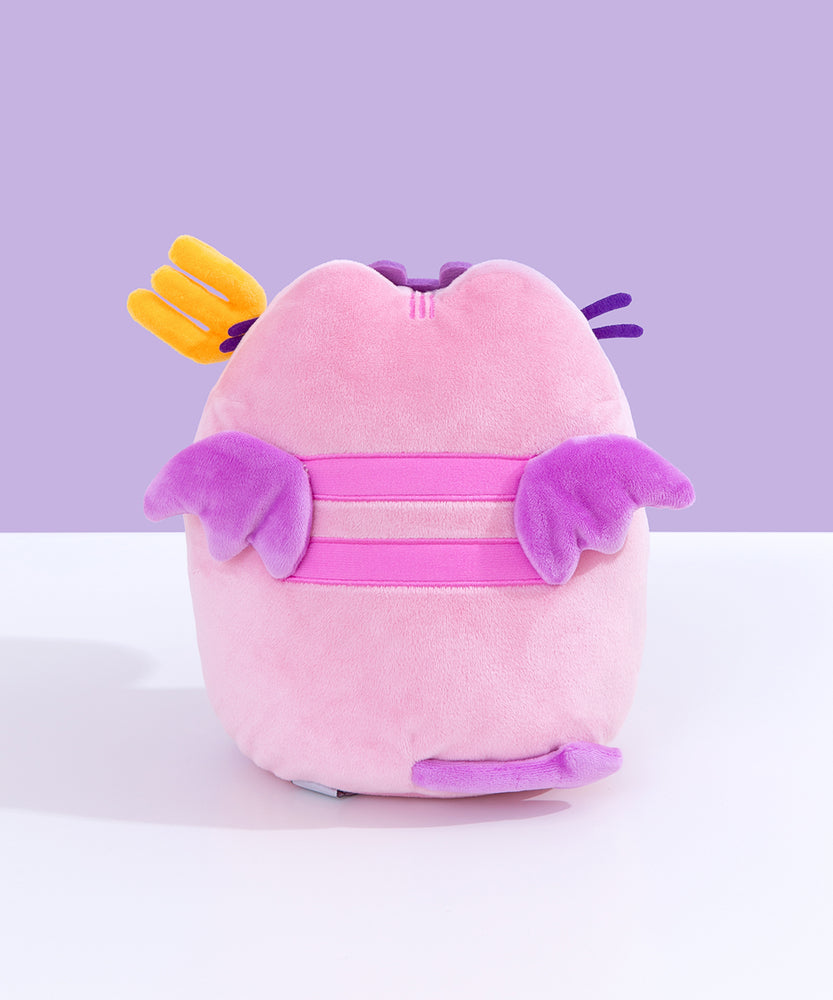 Back quarter view of Pusheen Devil’s Food Cake plush. This view shows Pusheen’s back stripes, plush purple wings, and brown cake peeking out the side.  