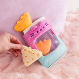 Model holds on of the light yellow triangle plush with dark yellow embroidery details. Each triangle plush features Pusheen's two triangle ears extending off the top of the plush.