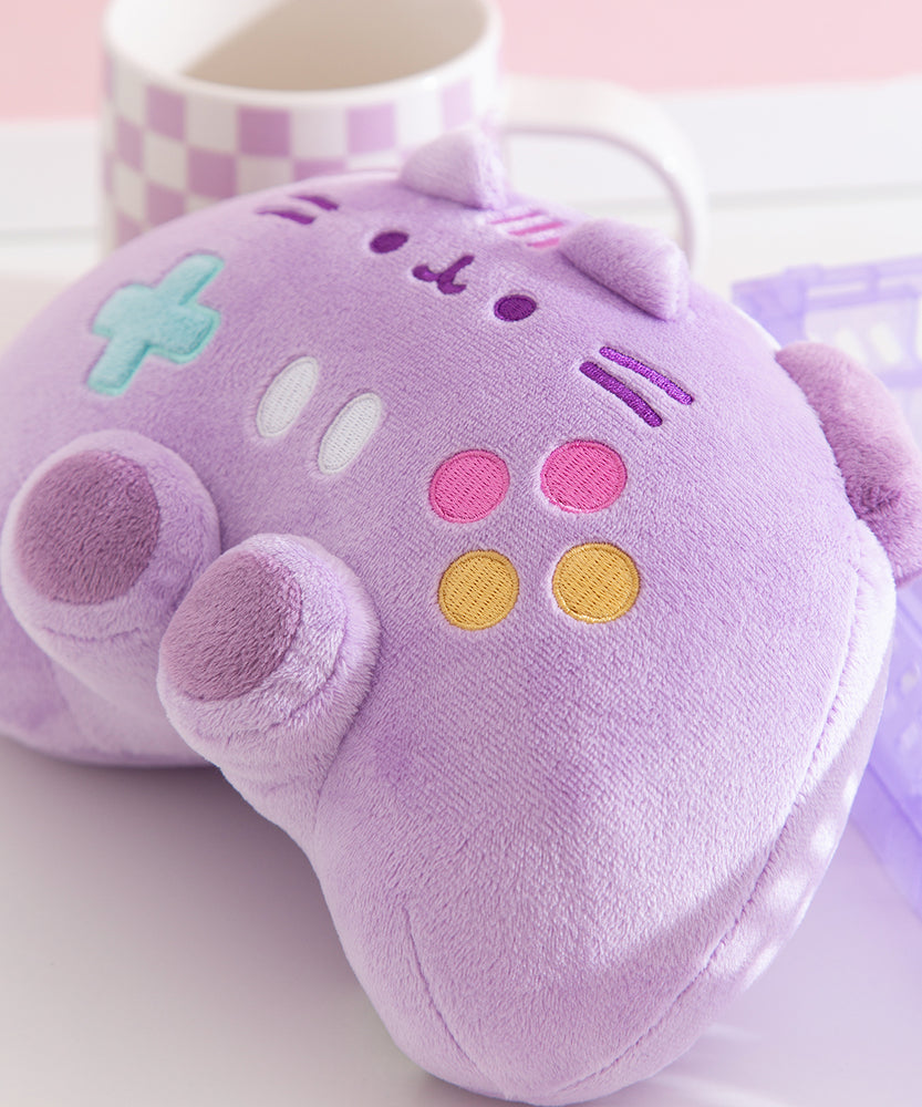 Close-up of the pink, yellow, white, and teal buttons embroidery detail on the front of the controller shaped plush.