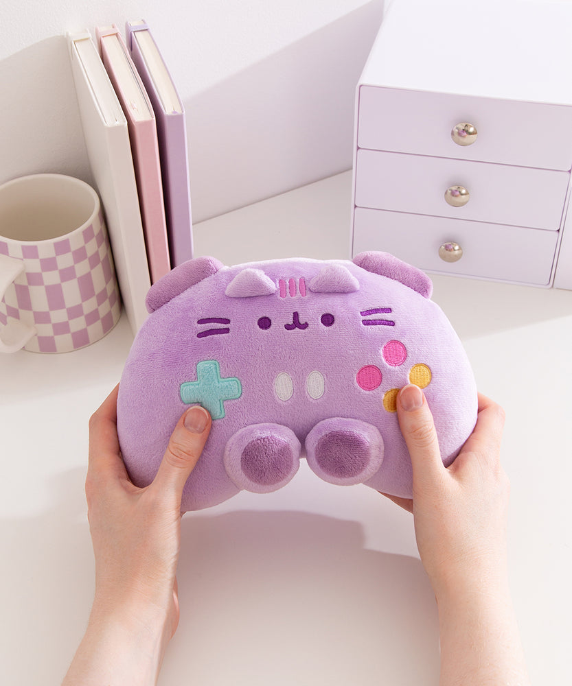 Model holding light purple Pusheen gaming controller plush to show size and scale of the plush toy.