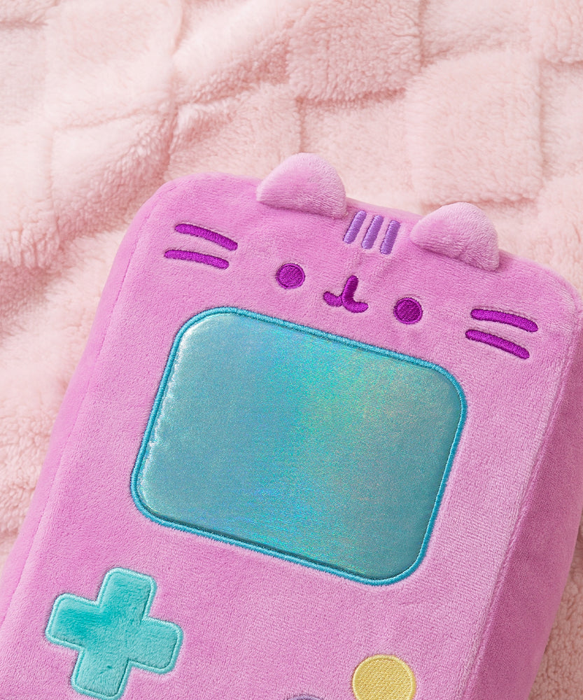 Close-up of Pusheen's face that's embroidered near the top front of the handheld plush. Pusheen's two triangle ears extend off the top front of the rectangle shaped plush. 