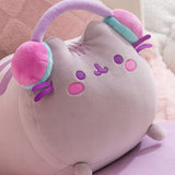 Close-up of the long gaming log plush toy. The grey cat has purple facial features embroidered on her face including eyes and mouth. Pusheen's classic three head stripes are embroidered between her two triangle shaped ears.