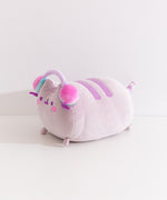Side view of the long chunky cat plush. The rotund plush features a cat lying down with her four paws extending off the front and back.
