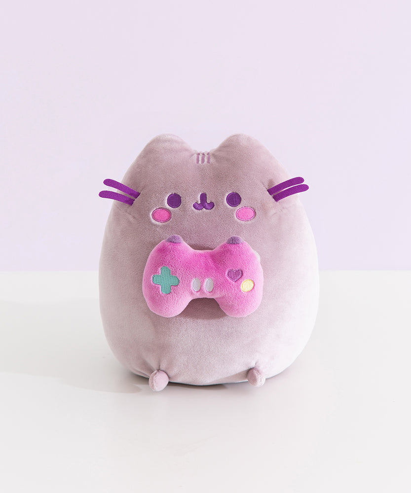 Front view of the Gamer Pusheen Plush toy. The grey cat has a purple hue and sits on her bottom so her four paws can be seen from the front.