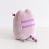 Back quarter view of the Pusheen gaming plush. Pusheen's two back stripes are embroidered in a medium purple color. Pusheen's gray and purple striped tail extends off the back bottom of the plush.