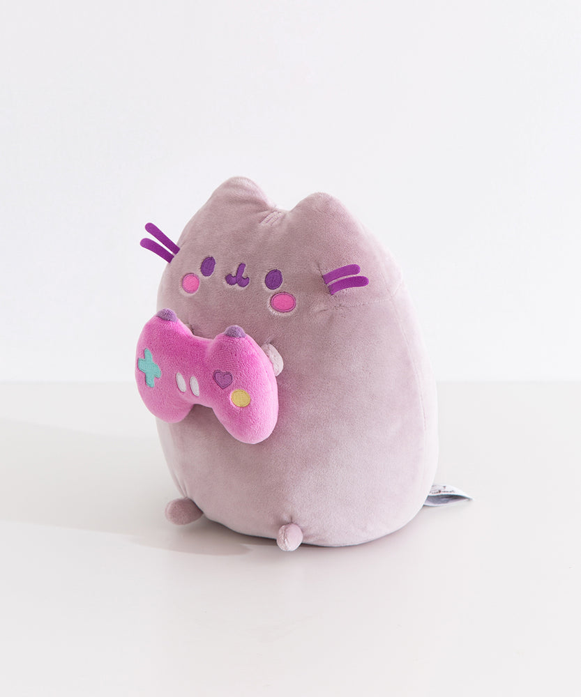 Side quarter view of the Pusheen gamer plush. Pusheen's classic three head stripes are embroidered in a light purple color between her triangle shaped 3D ears.