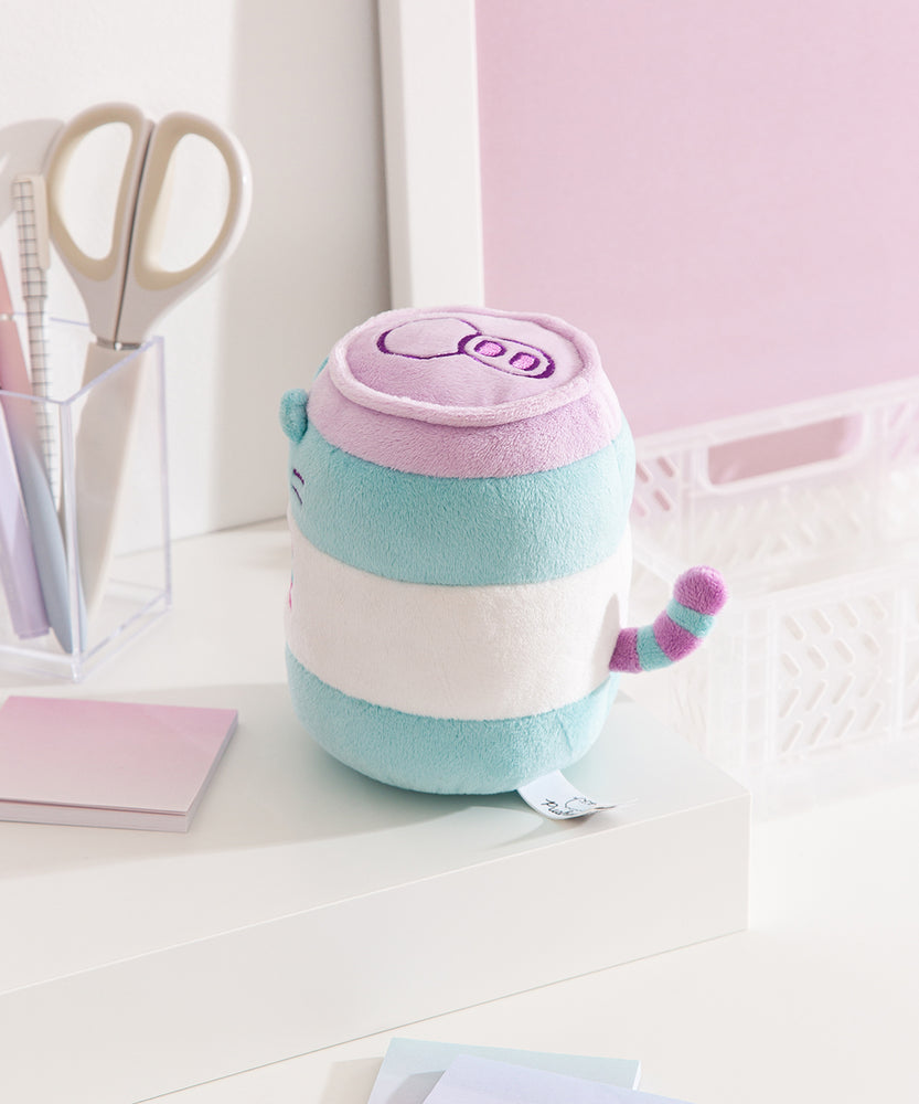 Side and back view of the Pusheen Pop Sip Plush. Pusheen's purple and blue striped tail colors match the lid and can elements on the plush toy. 