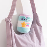 Pop Sip Plush can sits on top of a purple purse to show the small scale of the plush. 