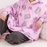 Model wearing a purple hooded blanket with cartoon cat designs and gaming accessories.