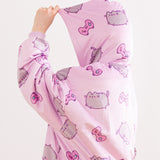 Model stands to the side while wearing the Gamer Pusheen Wearable Blanket Hoodie with the purple hood over their head. The print all over continues from the body onto the hood. The oversized hoodie fits most.  