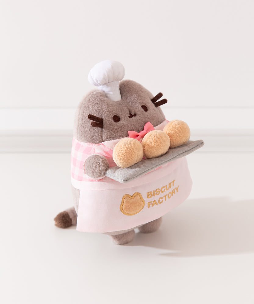 Side quarter side view of Baker Plush. Pusheen the Cat holds three biscuit buns on a light gray platter. 