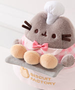 Top aerial view of Baker Pusheen plush to show off Pusheen’s three biscuit buns that are a creamy yellow color and the pink color of the tiny bow tie on the plush.