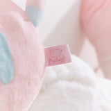 Close-up of the cggcw logo tag that is attached to the back bottom of the plush.