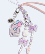 Close-up of the acrylic pastel removable charm on the Pusheen 15th Anniversary Beaded Phone Charm. The charm depicts a pastel-hued Pusheen the Cat holding blue, pink, and purple balloons. 