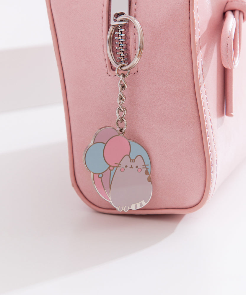 Silver keychain tilted to the side to show the reflective finish of the Pusheen keychain. 