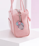 Silver pusheen keychain hangs off a pink zipper purse to show size and scale of the cat keychain. 