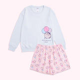 Pusheen 15th Anniversary Pajama Set lies as a set on a background. The oversized light blue sweatshirt has a graphic of Pusheen the Cat with balloons on the wearer's left. The stretchy patterned shorts have an all over pattern of Pusheen holding pastel balloons. 