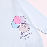 A close-up view of the graphic print on the 15th Anniversary Sweatshirt. The graphic shows Pusheen blushing next to blue, pink, and light purple balloons and the phrase "Pusheen forever" underneath. 