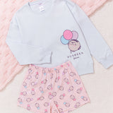 Light blue sweatshirt with cat design and pink shorts with ice cream pattern on a textured pink surface