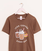 Brown t-shirt with a large graphic on the front center. The graphic shows Pusheen the Cat nestled in the whipped cream of an iced coffee with pink straw.