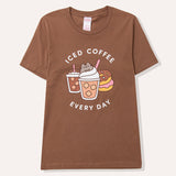 Coffee t-short lies on a flat surface. The brown tee has a large graphic in the center front of the t-shirt feauring Pusheen the Cat, two iced coffees, two iced donuts, and the phrase "Iced Coffee Every Day."