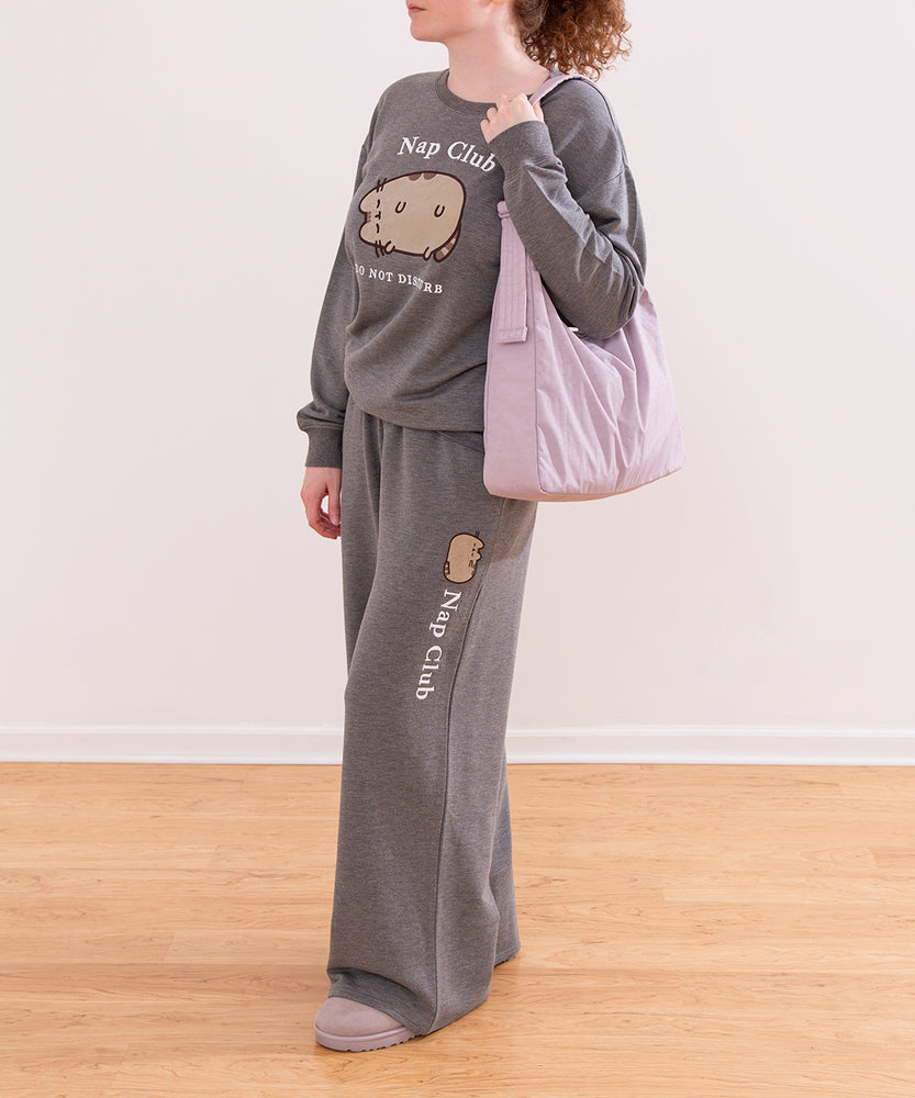 Modeal wearing a gray Pusheen Nap Club Loungewear Set. The matching set includes a sweatshirt and a wide-leg sweat pant.