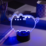 Purple LED light shaped like Pusheen the Cat on a desk with a laptop and cup in the background.