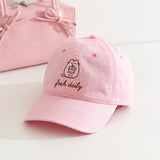 Fresh Daily Pusheen Sweets pink cap. The cat holds a cherry tiered mini cake. 