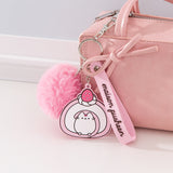 Pusheen Sweets Keyring attached to a pink purse. The keyring dangle features a a silicon swiss roll character dangle, pink pom, and a wrist loop. 