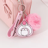 Close-up of the swiss roll Sweets Keychain attached to a pink purse. The keyring has a claw clip attachment.