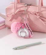 Chunky Pusheen Keychain attached to a pink purse. Pusheen the Cat is transformed inot a pink and white swiss roll topped with a pink and white strawberry and a white whipped cream dollop.