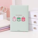 Back cover of the mint green Pusheen notebook. On the center of the back are three graphics of Pusheen the Cat transformed in macarons. On the left is a pink and white vanilla macaron, in the middle is a two-toned green matcha macaron, and on the right is a two-toned pink strawberry macaron. 