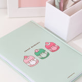 Back cover of the mint green notebook featuring Pusheen as multi-flavored macarons. Above the macarons graphic is the phrase "sweet moments" in brown text.