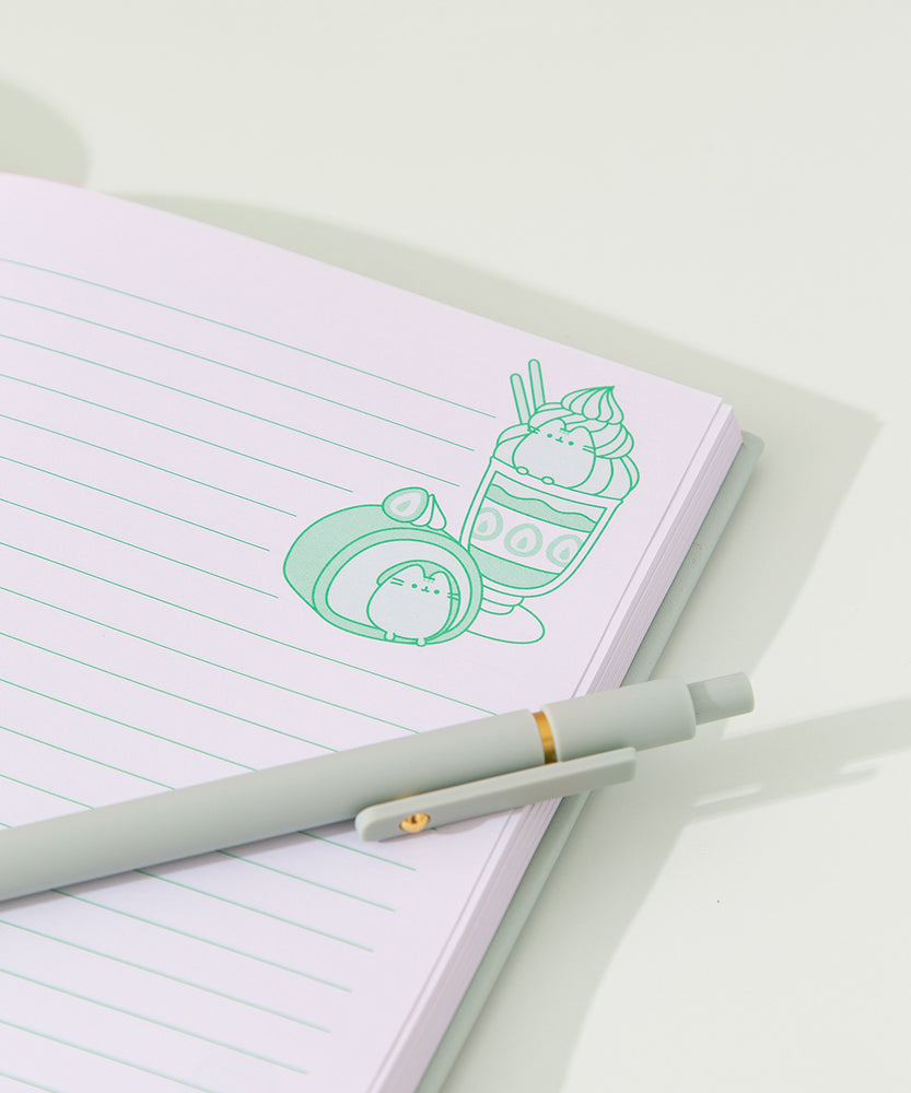 Model places the Pusheen notebook in a file divider to show size of the the mint green sweets-themed notebook.