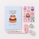 Contents of the Pusheen Sweets stationery set. The set includes a blue notebook, printed pencil, pencil sharpener, ballpoint pen, highlighter, stickers, and an eraser.