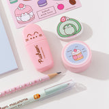 Close-up view of the highlighter, eraser, pencil sharpener, and writing utensils in the stationery set. The eraser features a matcha-flavored swiss roll. The pencil sharpener has a mini strawberry cake graphic. The writing utensils and accessories are all pink, mint green, and light blue.