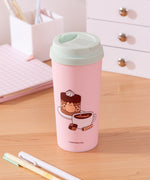 Alternate view of the coffee travel mug. The other large graphic includes Pusheen the Cat inside a sprinkle-tiered chocolate cake with a mocha latte next to the cake. 