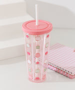 Full view of the sweets-themed water bottle with straw. The icons on the bottle include a whipped cream pile with a pink strawberry, a strawberry macaron, and a mini-tiered matcha-flavored cake.