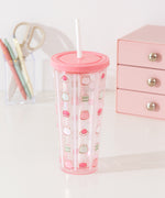 Pusheen water bottle with straw sits atop a desktop. The clear base as light pink hues at the top and bottom of the cup.