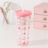 Pusheen water bottle with straw sits atop a desktop. The clear base as light pink hues at the top and bottom of the cup.