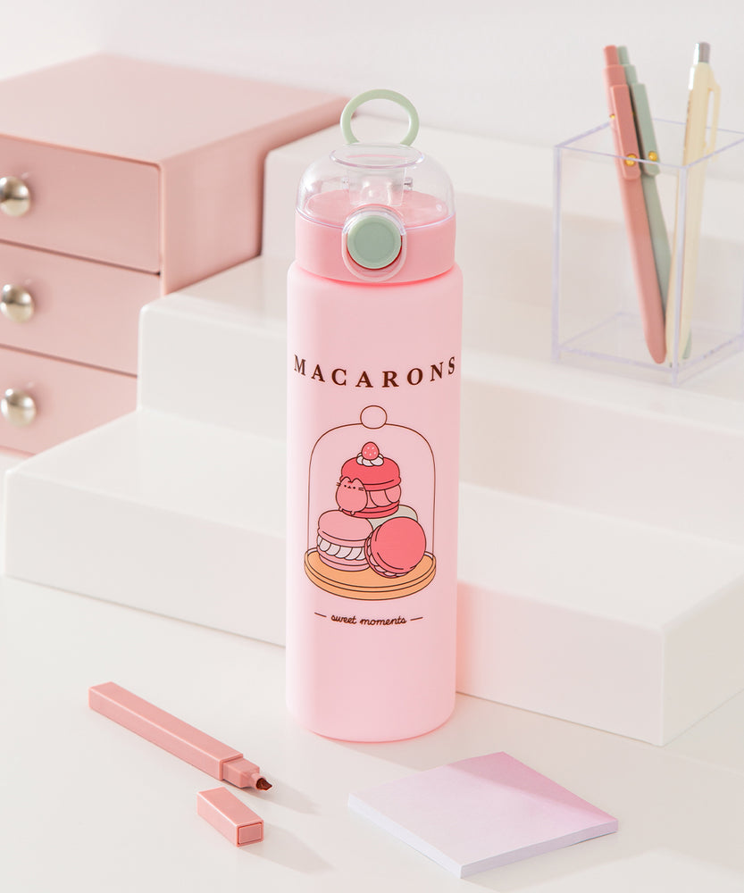 Front view of Pusheen Water Bottle. On the front of the bottle is a graphic of three macarons in a pastry case. Above the graphic is the phrase "macarons" while below the graphic is the phrase "sweet moments."