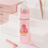 Front view of Pusheen Water Bottle. On the front of the bottle is a graphic of three macarons in a pastry case. Above the graphic is the phrase "macarons" while below the graphic is the phrase "sweet moments."