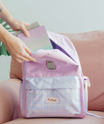Model places notebooks and stationery inside the top half-moon zippered pocket of the two-toned purple backpack.
