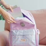 Model places notebooks and stationery inside the top half-moon zippered pocket of the two-toned purple backpack.