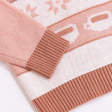 Close-up of the ribbing detail at the cuffs and bottom hem of the knit seater. The brown color matches the knit color shown in the repeating pattern near the sweater's hem.