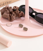 Pink jewelry stand with Pusheen Coffee Stud earrings, ring, and sunglasses on a white surface
