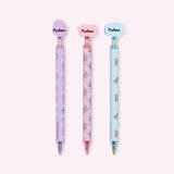 Back view of the three gel pens with decorative Pusheen tops. The back of the silicone toppers have the Pusheen the Cat logo in brown.